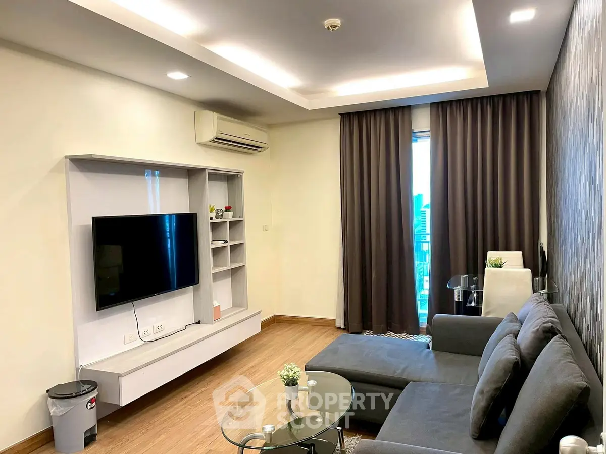 Modern living room with sleek furniture and large TV, perfect for relaxation.