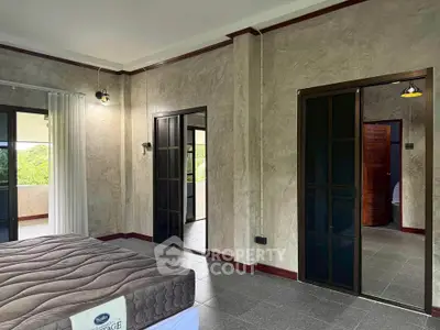 Spacious bedroom with sliding doors and scenic balcony view