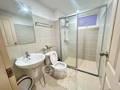 Modern bathroom with glass shower enclosure and sleek fixtures in a contemporary home.