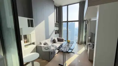 Modern living room with high ceiling and city view, featuring sleek furniture and large windows.