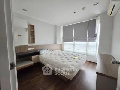 Modern bedroom with large window and minimalist design in a high-rise apartment.