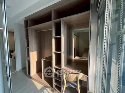 Spacious walk-in closet with wooden shelves and natural light in modern apartment.