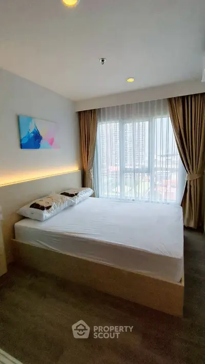 Modern bedroom with large window and stylish decor in a high-rise apartment.