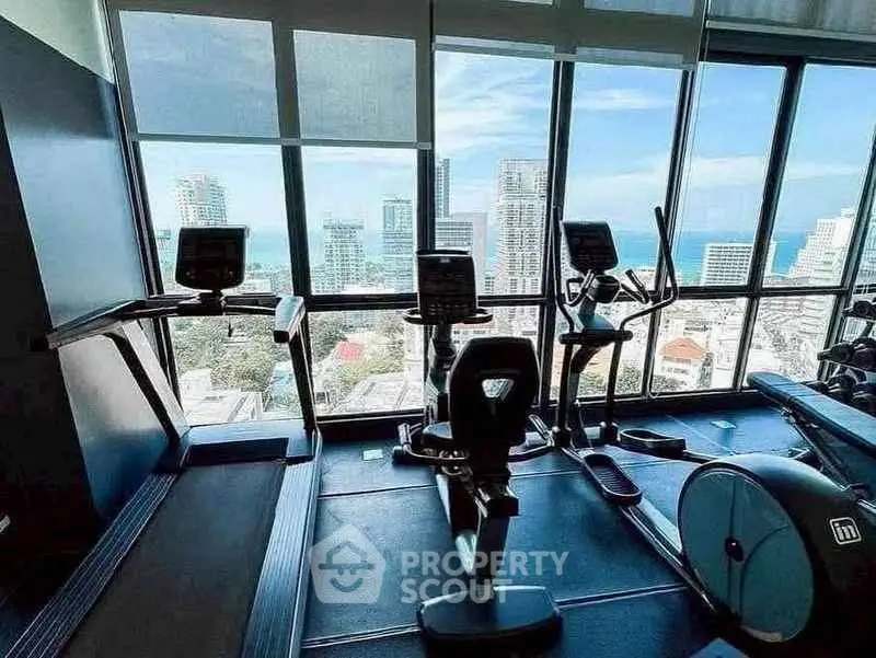 Modern gym with panoramic city view and state-of-the-art fitness equipment.