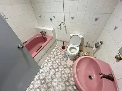 Charming vintage bathroom with pink fixtures and classic tile design, perfect for a retro-inspired home.