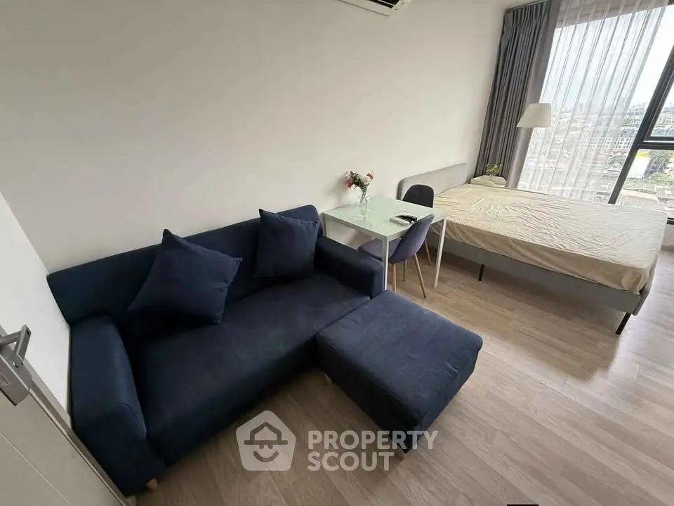 Modern studio apartment with cozy living area and large window view
