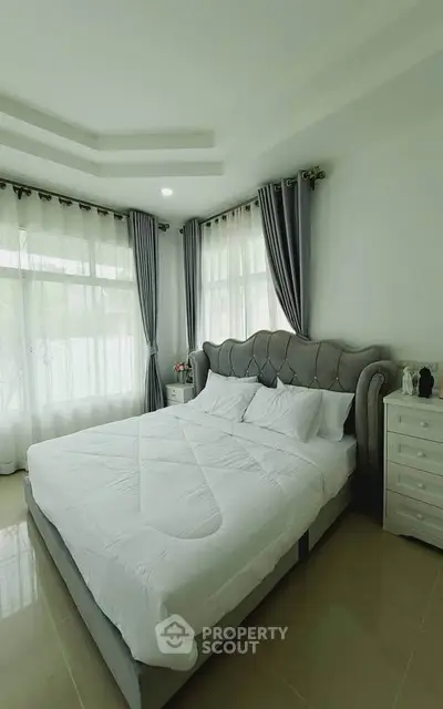 Elegant bedroom with plush bed and large windows for natural light