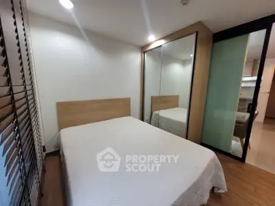 Cozy bedroom with mirrored closet and modern design in a stylish apartment.