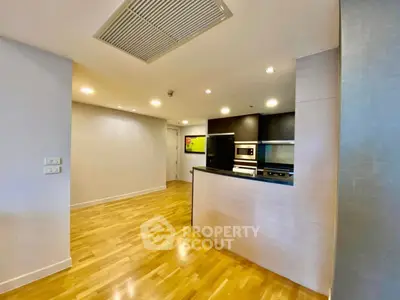 Modern open-layout kitchen with sleek appliances and wooden flooring