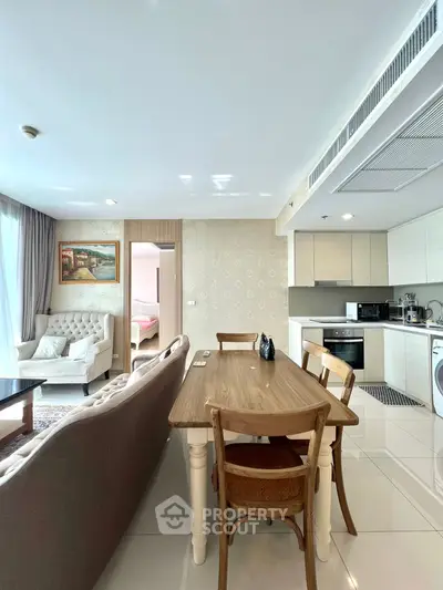 Chic open-plan living room with modern kitchen and cozy dining area in stylish apartment.