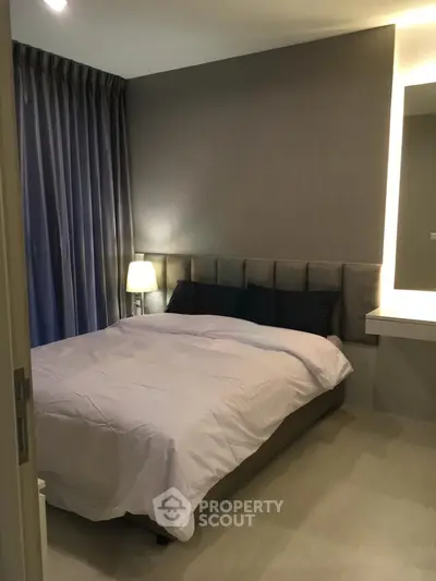 Cozy modern bedroom with elegant lighting and plush bedding in a stylish apartment.