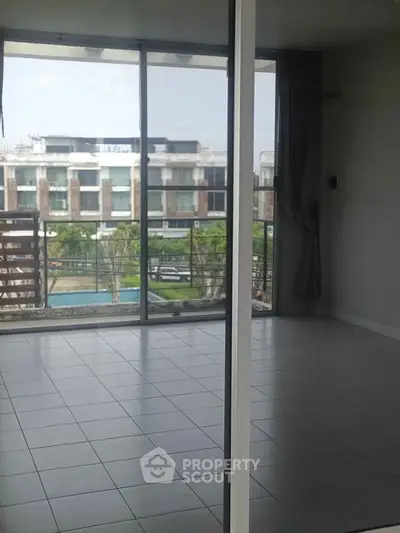 Spacious modern living room with large windows and balcony view
