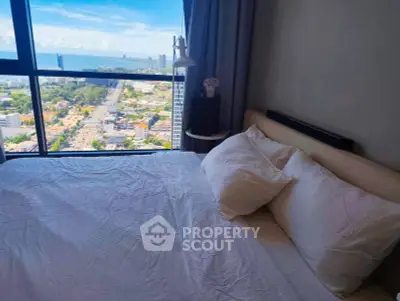 Luxurious bedroom with stunning city and ocean view from high-rise window.