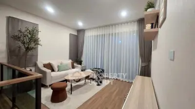 Modern living room with cozy sofa, elegant decor, and large window with curtains.