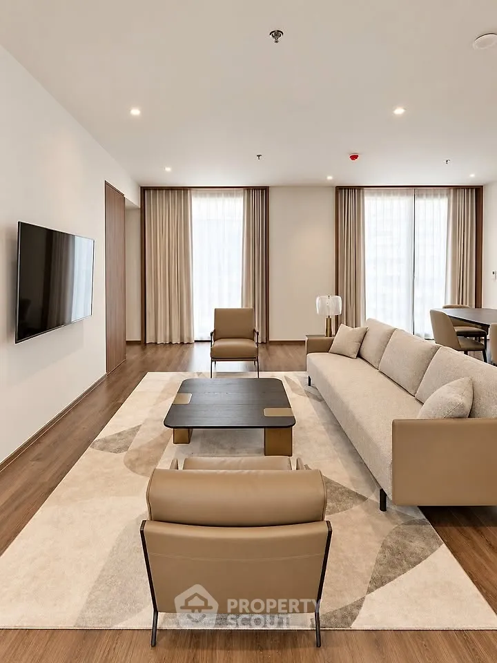 Spacious modern living room with elegant furniture and large windows for natural light.