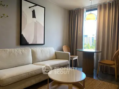 Stylish living room with modern decor, featuring a cozy sofa, elegant artwork, and a bright window view.