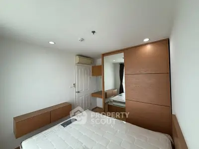 Modern bedroom with wooden accents and built-in wardrobe in a bright apartment.