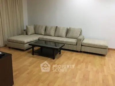 Spacious living room with elegant sectional sofa and wooden flooring