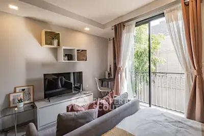 Modern living room with balcony view, stylish decor, and natural light