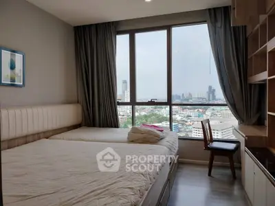 Cozy bedroom with city view, featuring large window and modern furnishings.