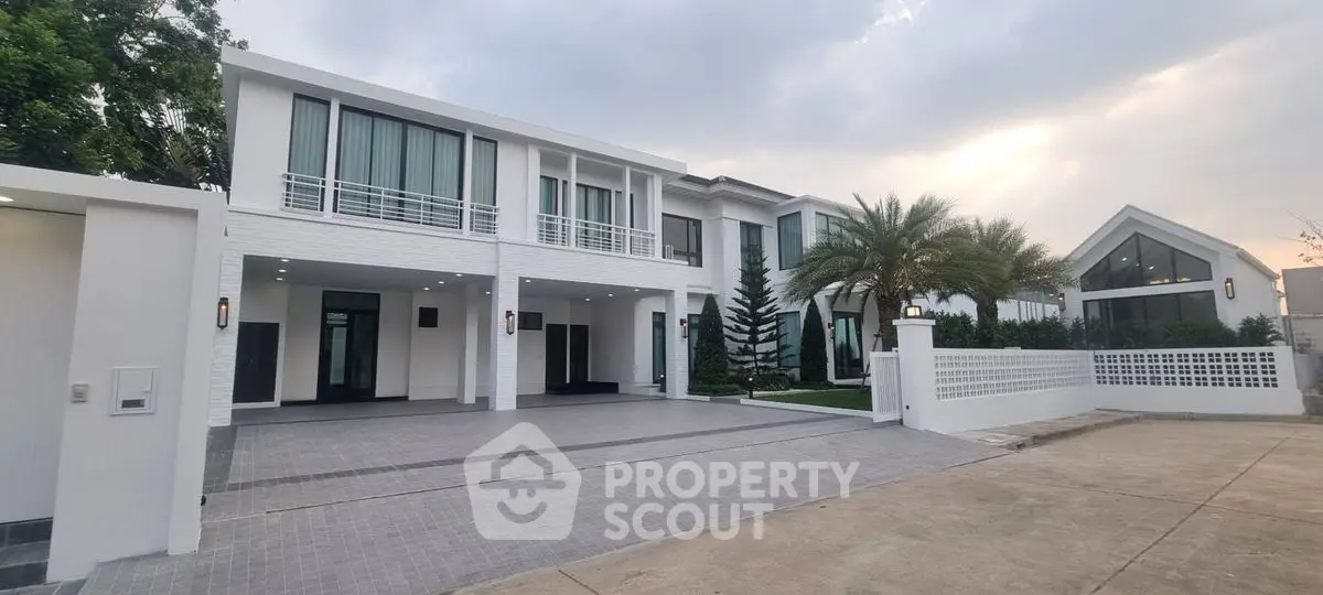 Luxurious modern white villa with spacious driveway and palm tree landscaping