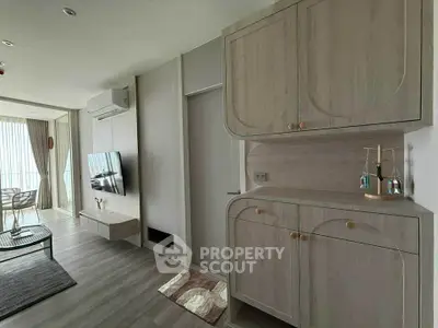 Modern living room with stylish cabinetry and wall-mounted TV, featuring elegant decor and natural light.