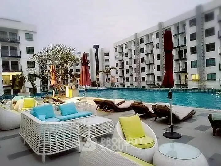 Luxurious apartment complex with inviting poolside lounge area and modern architecture.