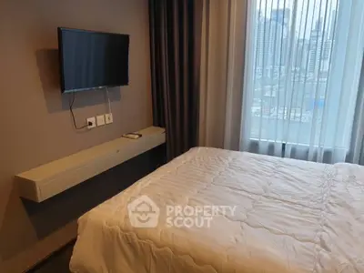 Modern bedroom with wall-mounted TV and city view from window