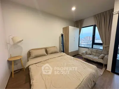 Modern bedroom with city view, cozy bed, and stylish decor in urban apartment.