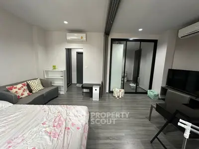 Modern studio apartment with sleek design, featuring a cozy bed, stylish sofa, and contemporary decor.