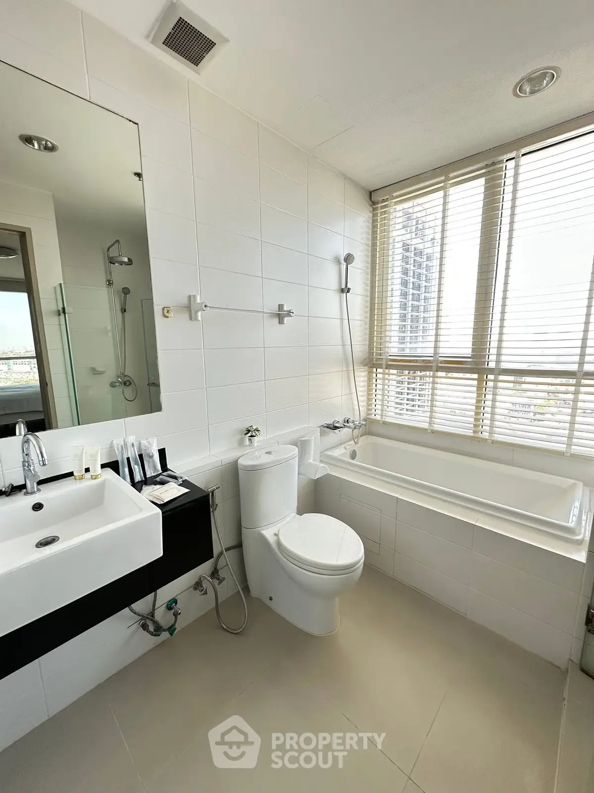 Modern bathroom with bathtub and large window offering city view