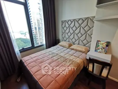 Cozy bedroom with modern decor and city view, featuring a stylish headboard and compact workspace.