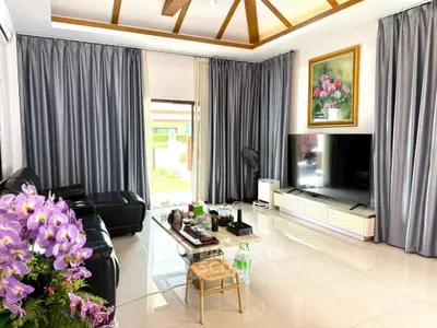 Spacious living room with modern decor and large TV, perfect for relaxation.