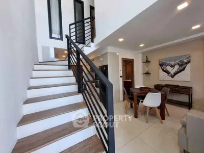 Modern duplex interior with stylish staircase and dining area