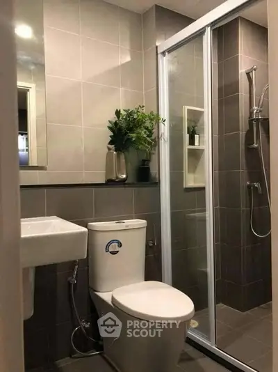 Modern bathroom with sleek design, featuring a glass shower enclosure and stylish fixtures.