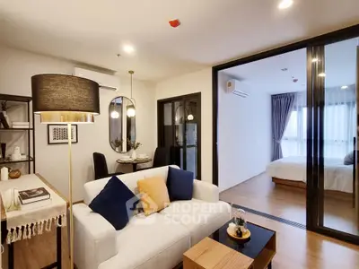 Modern open-plan living room with cozy dining area and sliding doors to bedroom.