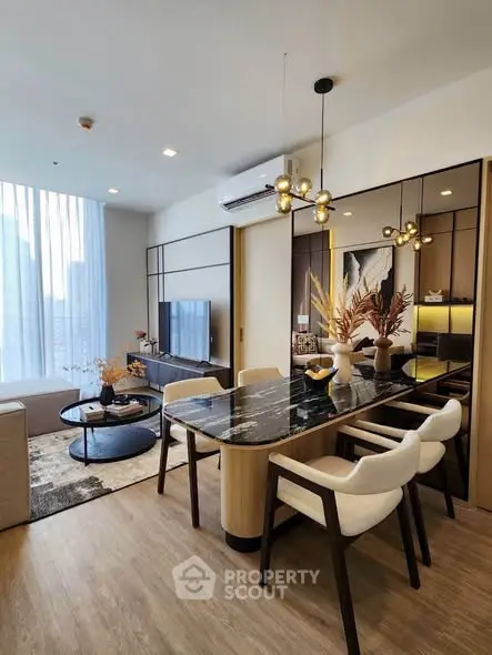 Modern living room with stylish dining area and city view, featuring elegant decor and natural light.