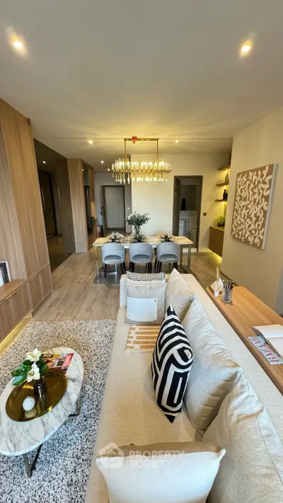 Luxurious open-plan living room with elegant decor and modern chandelier, perfect for stylish urban living.