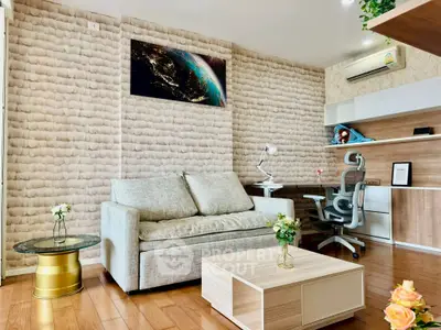 Modern living room with stylish decor and workspace, featuring a cozy sofa and wooden flooring.