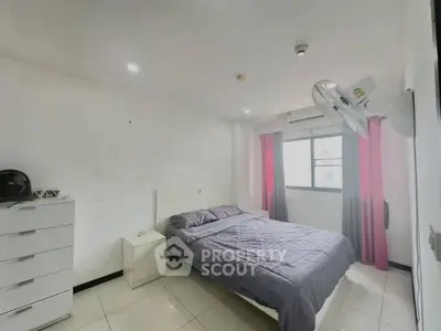 Spacious bedroom with modern decor and ample natural light.