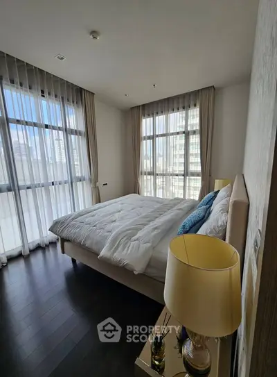 Luxurious bedroom with city view, featuring elegant decor and large windows for natural light.