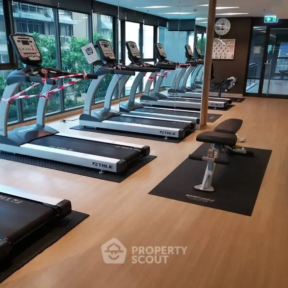 Modern gym with treadmills and benches in a residential building