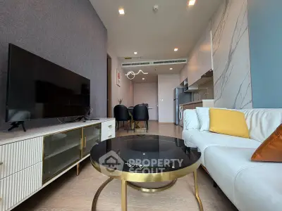 Modern living room with sleek furniture and open kitchen layout in a stylish apartment.