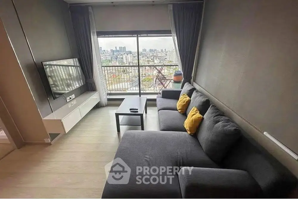 Modern living room with city view, featuring sleek furniture and large windows.