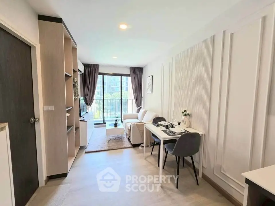 Modern living room with stylish decor and balcony view in a contemporary apartment.