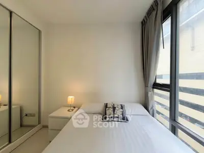 Bright and cozy bedroom with large windows and mirrored closet doors.