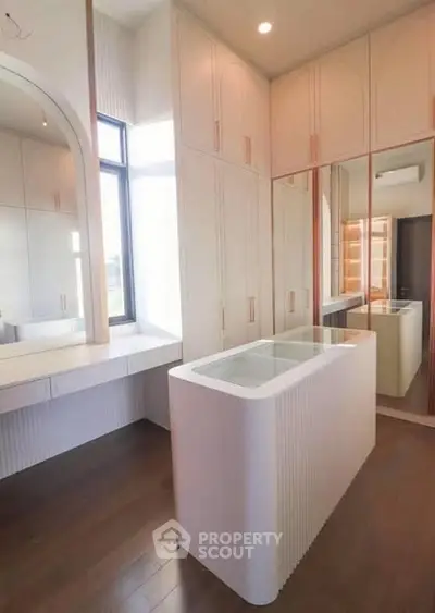 Luxurious walk-in closet with elegant cabinetry and ample natural light.