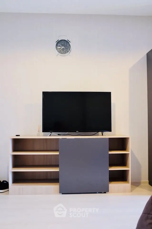 Modern living room with sleek TV stand and wall-mounted clock, perfect for contemporary homes.