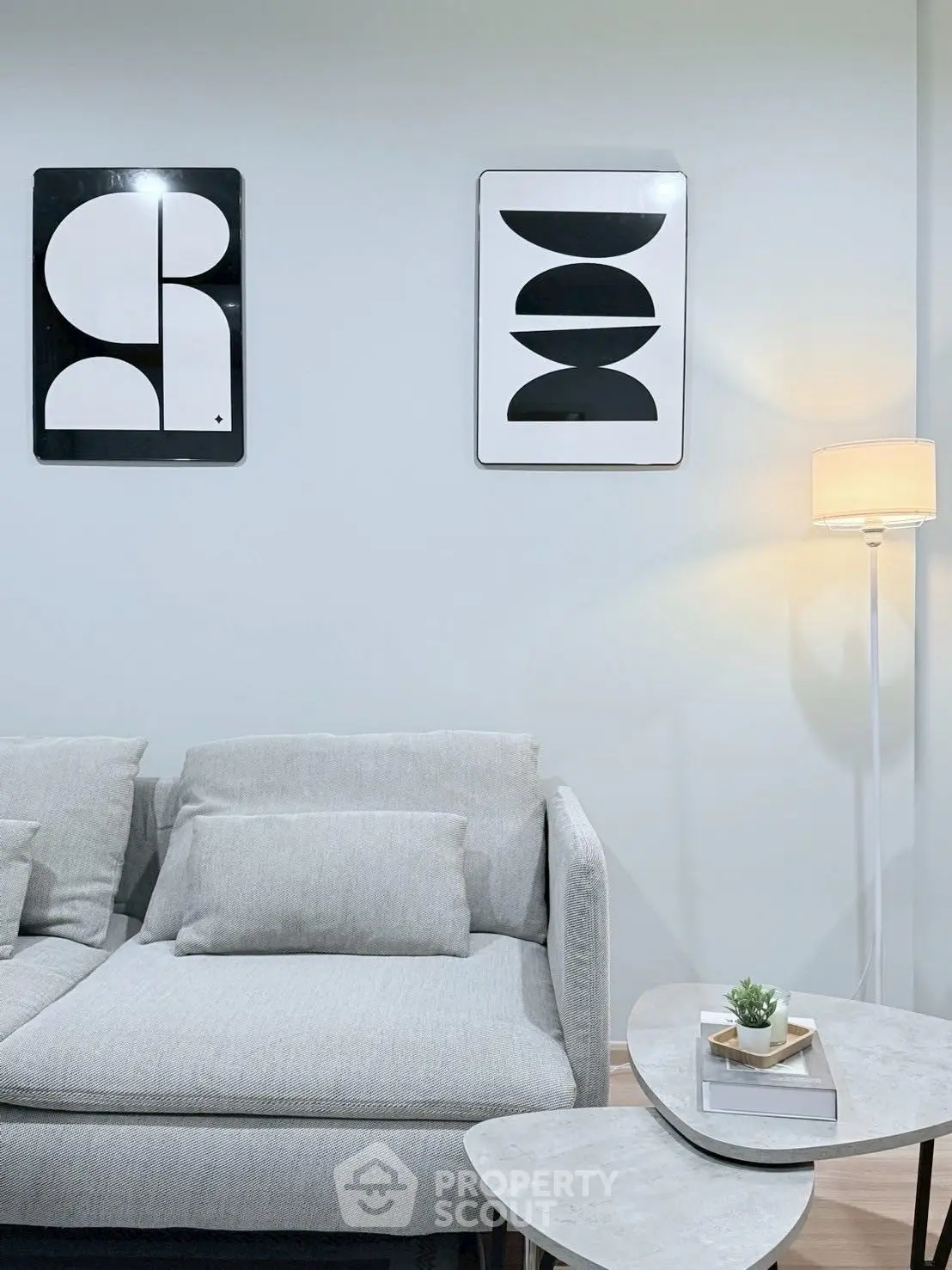 Modern living room with stylish gray sofa and abstract wall art