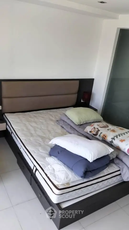 Modern bedroom with sleek bed frame and cozy pillows in a bright, minimalist design.